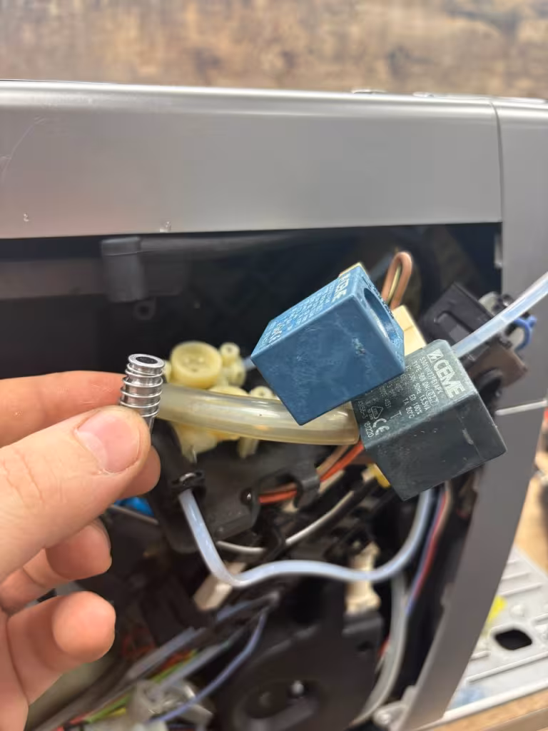 Zatkany układ wodny ekspresu DeLonghi z osadami kamienia